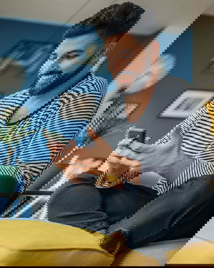 person-mit-handy-auf-couch